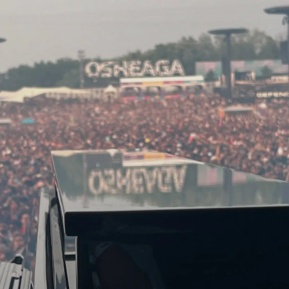 Huge festival crowd seen from the stage under an Osheaga sign